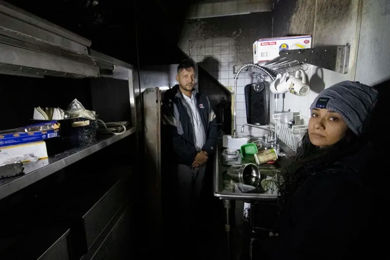 Christiana Marie Ruiz-Penaloza and her husband, Mario Penaloza, are photographed at their fire damaged kitchen inside Manny Vibez, their restaurant in Norwood.