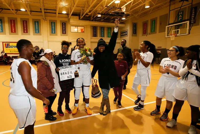 LEAP Academy Charter senior Brazil Harvey-Carr (holding flowers) celebrates her 2,000th career point with family, teammates and friends.