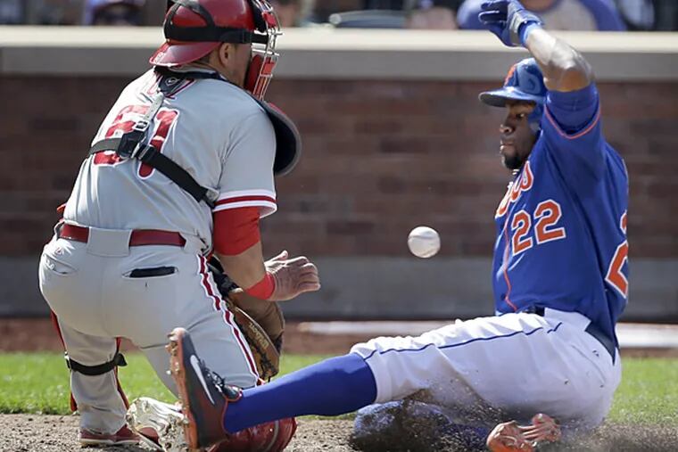 New York Mets' Eric Young Jr., right, slides safely home before the ball reaches Philadelphia Phillies catcher Carlos Ruiz during the sixth inning of the baseball game at Citi Field Thursday, Aug. 29, 2013 in New York. (AP Photo/Seth Wenig)