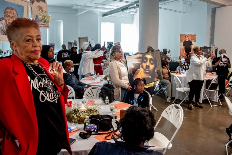 Attendees hold up portraits of their late loved ones at an event hosted by Mothers In Charge on National Day of Remembrance, a day of healing for the families of gun violence victims.