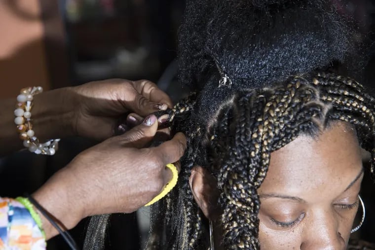 Brigitte K. Nzali braids the hair of a customer at the African & American Braiding, Inc in Blackwood, N.J.  Nzali, from Cameroon, has been fighting for 17 yrs to get the state to understand that braiding should not fall under cosmetology and hair styling because no chemicals are used and because she says its a "cultural tradition" and not a styling technique to be taught in beauty school.