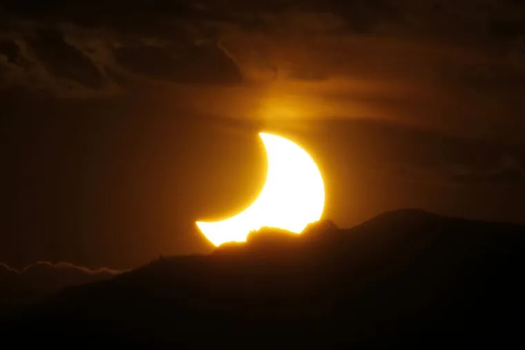 An annular solar eclipse in May 2012, seen from downtown Denver as the sun sets behind the Rocky Mountains.