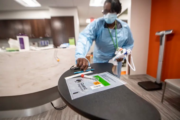 Health care worker, Antoinette Killing, prepares a COVID-19 kit  to be tested on a COVID rapid equipment/machine at the Vybe Urgent Care in Philadelphia, Pa. Friday August 21, 2020. Vybe urgent care recently started offering rapid 15-minute COVID tests at their centers.