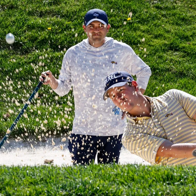 Drexel golf coach Ben Feld working with Oscar Maxfield in the sand trap at Green Valley Country Club in Lafayette Hill, Monday, April 15, 2024.
