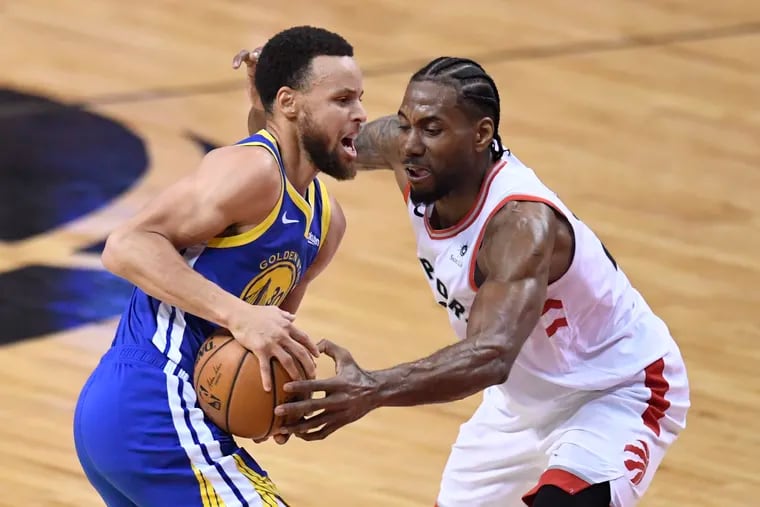 Toronto Raptors forward Kawhi Leonard (2) defends against Golden State Warriors guard Stephen Curry (30) during the first half Monday.