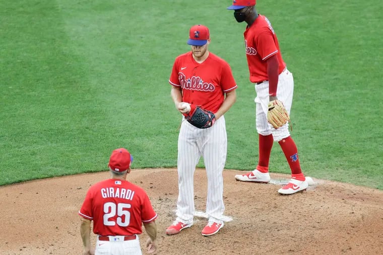 Phillies pitcher Zack Wheeler waits for manager Joe Girardi to take him out of the game as shortstop Didi Gregorius looks on during Sunday's exhibition game at Citizens Bank Park.