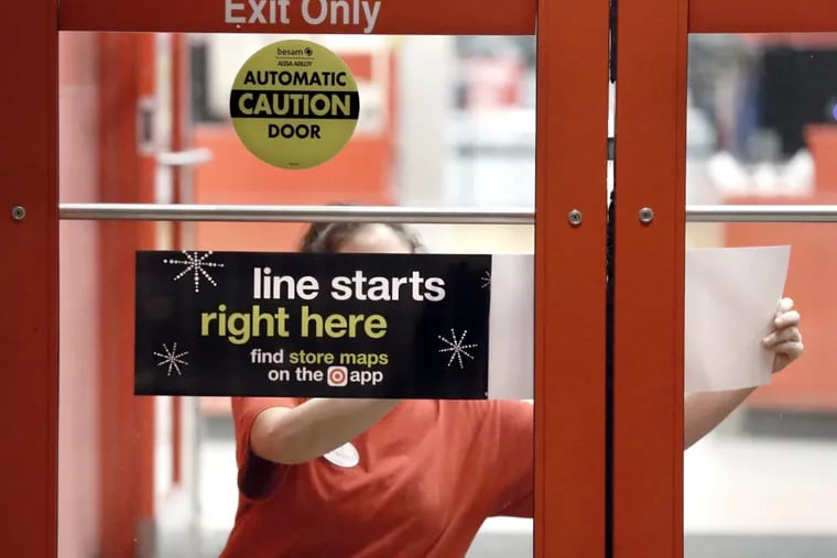 At the Deptford Target, Tina Pinto posts a sign on the front door, preparing for last year&#039;s Thanksgiving crush.