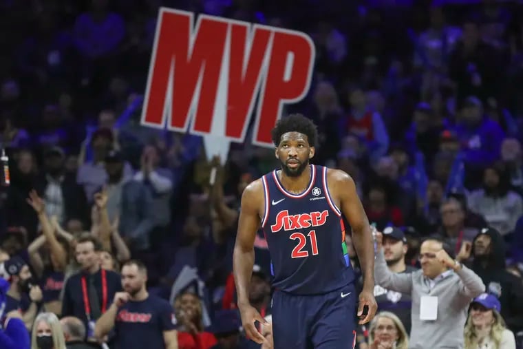 MVP sign is seen behind Philadelphia 76ers center Joel Embiid (21) after he hit a three-pointer in the fourth quarter of a game against the Milwaukee Bucks at the Wells Fargo Center in Philadelphia on Tuesday, March 29, 2022.