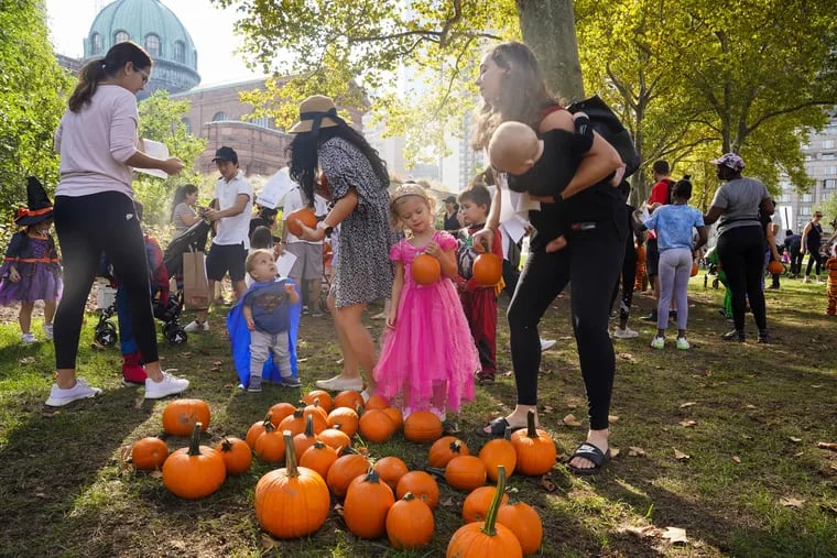 Gabi Johnston, 3, dressed as princess, picks a pumpkin at the Trick-or-Treat Scavenger Hunt event at Sister Cities Park.