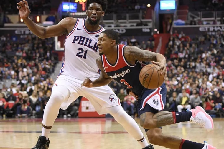 Wizards guard Bradley Beal drives to the basket against  76ers center Joel Embiid.