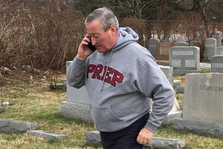 Mayor Jim Kenney talks on his phone as he surveys the damage at Mount Carmel Cemetery in February 2017.