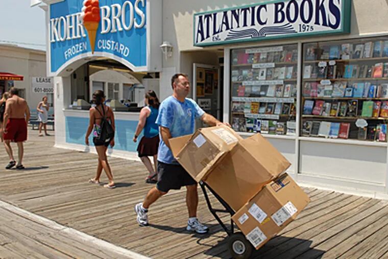 Brent Hanley, owner of the Shirt Shack the Boardwalk in Ocean City, wheels merchandise to his store. (Peter Tobia / Inquirer)