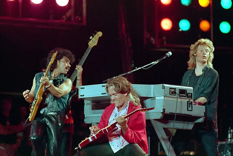 From left, John Oates, G.E.Smith and Daryl Hall perform collectively as Hall and Oates onstage at JFK Stadium in Philadelphia Pa. for the Live Aid famine relief concert July 13, 1985.(AP Photo/Amy Sancetta)