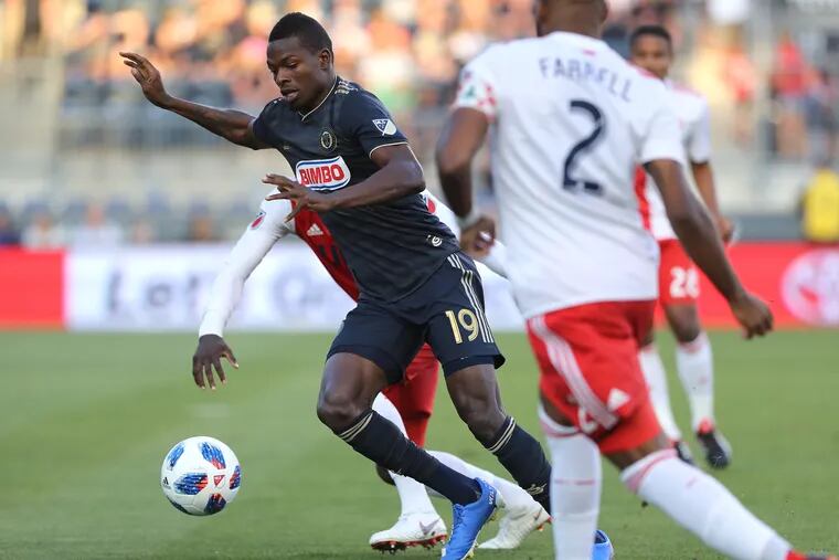 Cory Burke, left, of the Union makes his way through Revolution defenders during the first half of their game at Talen Energy on Aug. 25, 2018.