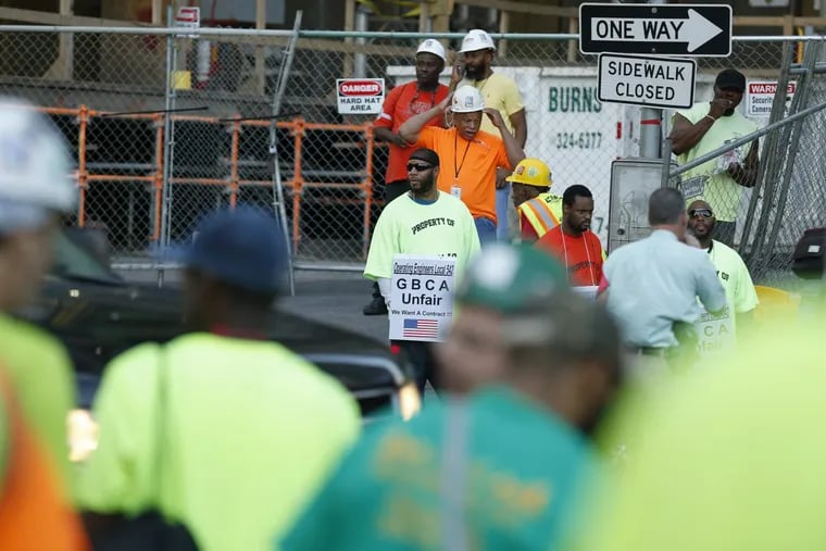 Union workers gather outside the construction site as union crane operators protest in front of the Comcast tower in Philadelphia, PA on Friday.