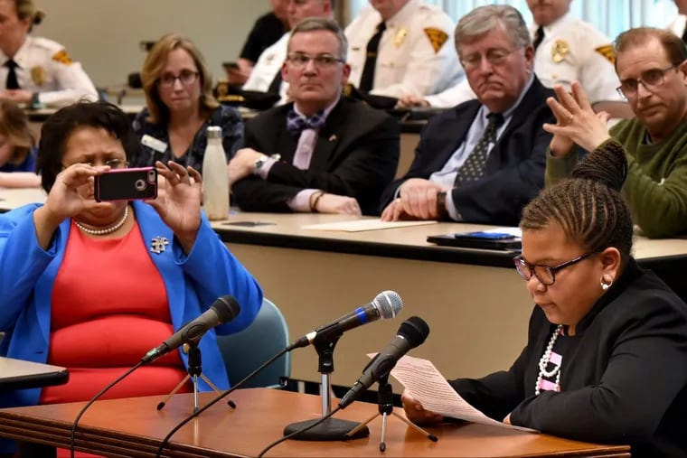 Carlyne Beverly (left) records her daughter Candace Beverly (right) reading her testimony before a joint hearing of the N.J. Senate and Assembly Committees on school security at Camden County College.