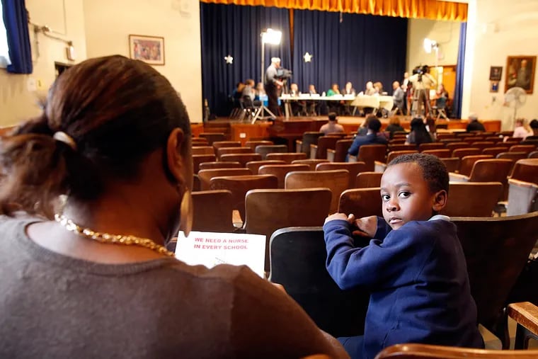 Franklin S. Edmonds Elementary School first-grader Avery Richardson sits next to mother Tara Glenn during a special safety hearing at the school on Thursday.
