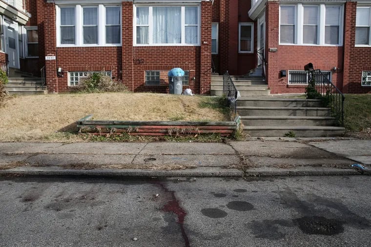 Blood remains on the street in front of a home in the 5600 block of Mascher Street in Philadelphia's Olney section on Wednesday, Dec. 25, 2019. Police say a woman was fatally stabbed by a man with a butcher knife early Christmas morning.