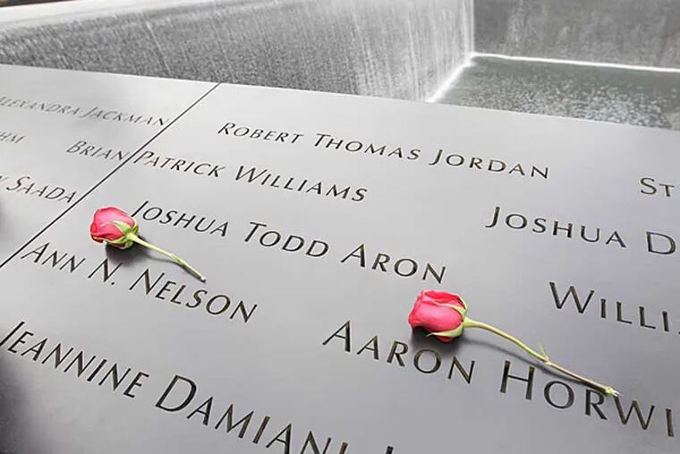 Roses lay on the north pool placed by Dawn Nelson in memory of her sister Ann N. Nelson and Aaron Horwitz at the National September 11 Memorial during a ceremony marking the 10th anniversary of the attacks at World Trade Center, Sunday, Sept. 11, 2011 in New York.  (AP Photo/Mary Altaffer)