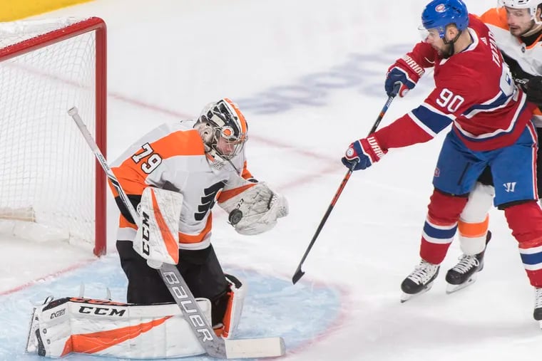 Carter Hart tries to stop a shot attempt by the Canadiens' Tomas Tatar on Saturday in Montreal.