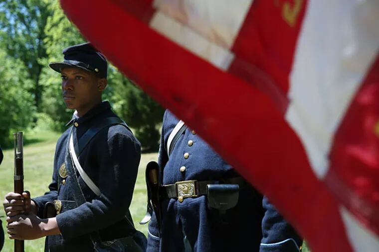 Samir Burrell, of Trenton, a reenactor with the Sixth Regiment U.S. Colored Troops, listens during a salute in Timbuctoo, Westampton Township, N.J., on May 23, 2015. (DAVID MAIALETTI/Staff Photographer)