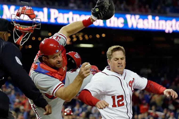 Erik Kratz (31) hangs on to the ball to make the tag on Washington Nationals' Tyler Moore (12) for the out at home during the fourth inning of a baseball game at Nationals Park, Friday, May 24, 2013, in Washington. (Alex Brandon/AP)
