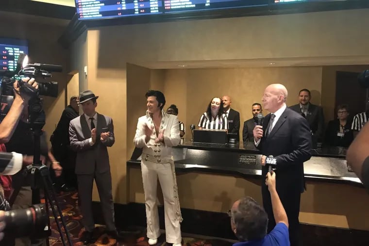 Frank Sinatra and Elvis Presley impersonators help Caesars regional president Kevin Ortzman open the sportsbook at Harrah's in Atlantic City on Aug. 1, 2018.