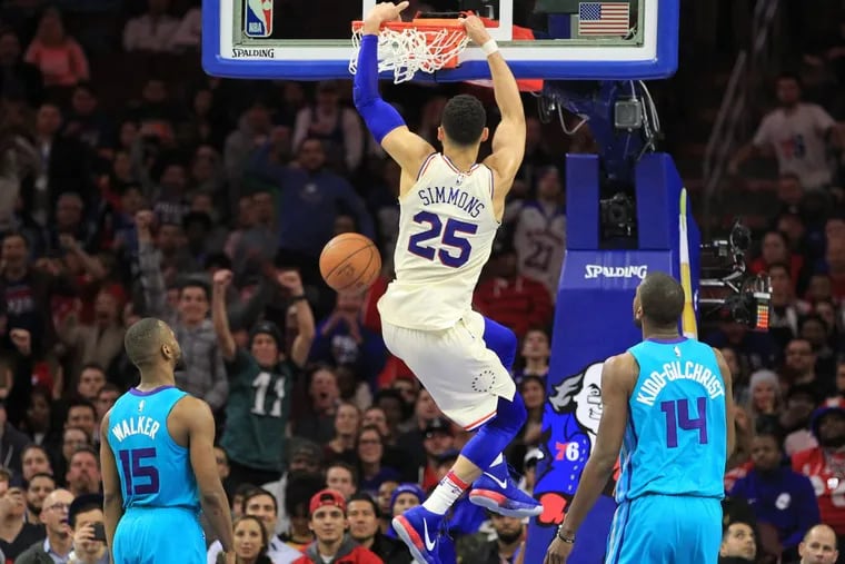 Ben Simmons, center, of the Sixers dunks between Kemba Walker, left, and Michael Kidd-Gilchrist of the Hornets during the 4th quarter at the Wells Fargo Center on March 2, 2018.