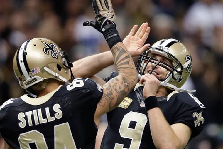 Saints quarterback Drew Brees (9) celebrates with wide receiver Kenny Stills (84) after a touchdown pass in the second half of an NFL football game in New Orleans, Sunday, Nov. 10, 2013. (Dave Martin/AP)