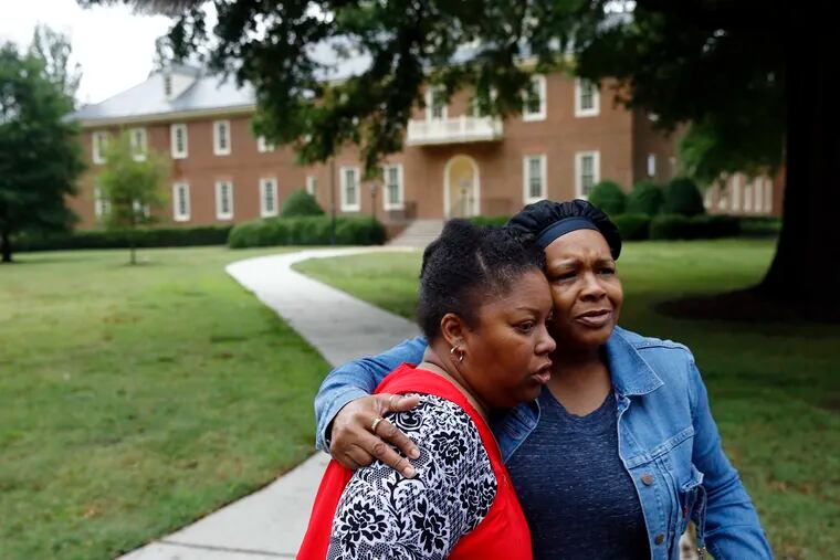 Shelia Cook, left, and Renee Russell, members of Mount Olive Baptist Church, embrace after praying near a municipal building that was the scene of a shooting, Saturday, June 1, 2019, in Virginia Beach, Va. A longtime city employee opened fire at the building Friday before police shot and killed him, authorities said.