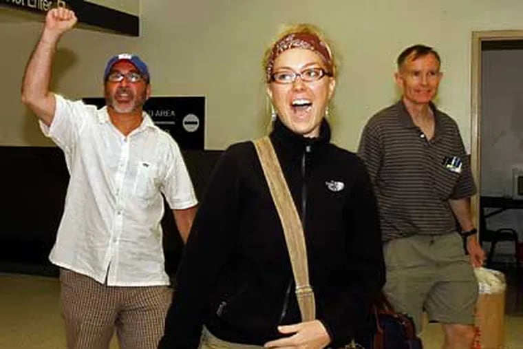 Rev. Patrick Mahoney, left, Brandi Swindell, center, and Mike McMonagle greet supporters upon arrival at Los Angeles International Airport on Thursday in Los Angeles. They were detained by Chinese officials after protesting on Tiananmen Square. (AP Photo/Nick Ut)