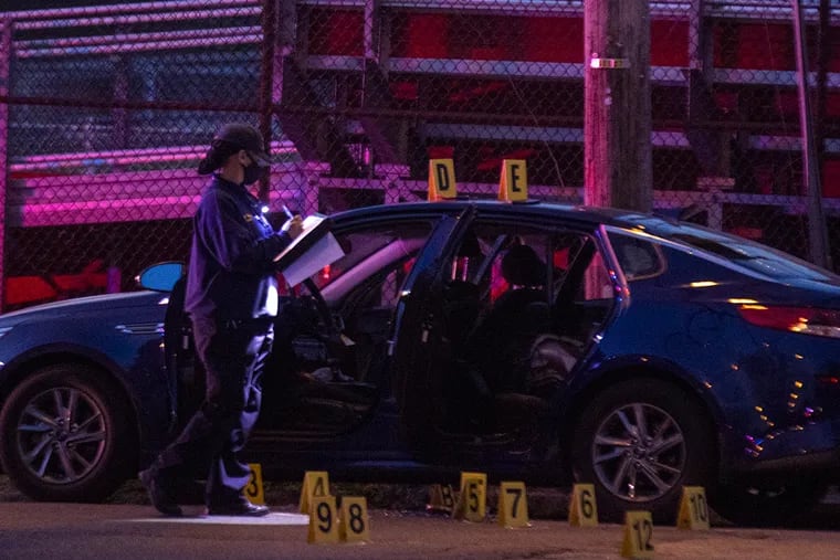 Philadelphia crime scene unit laying down evidence markers after gunfire left 24-year-old man dead and officer wounded at 15th Street and West Somerville Avenue in North Philadelphia on Wednesday, April 7, 2021.