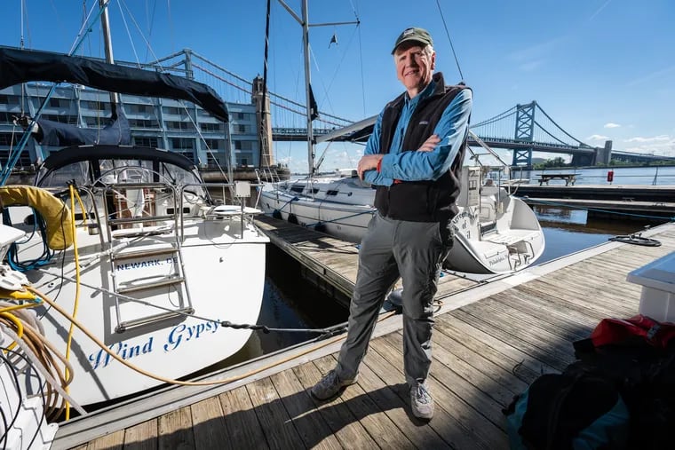 Don Baugh shown here next to his sailboat, where he lives during the week, on the waterfront in Philly near the Ben Franklin Bridge.