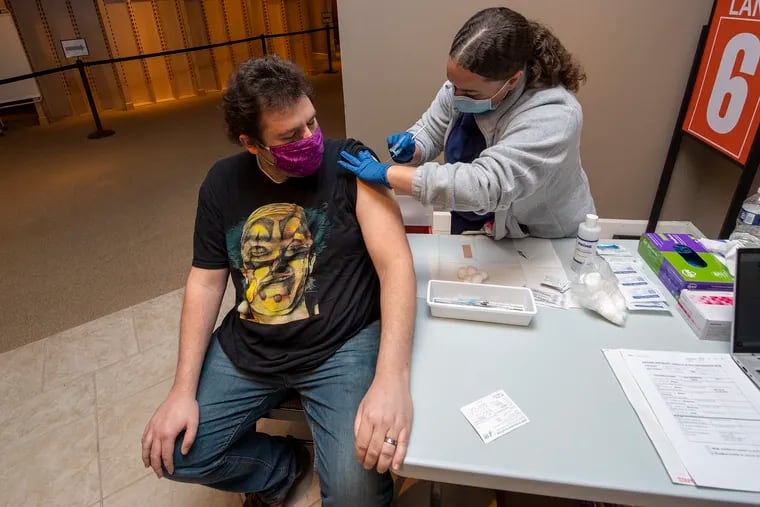 Licensed Practical Nurse, Jada DiRocco, right, administers a Pfizer vaccine booster, to Ben Grandizio, on Wednesday, December 1, 2021., at the Montgomery County vaccine clinic in the King of Prussia Mall.