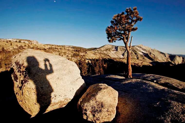 A photographer at Olmsted Point casts her shadow in Yosemite National Park in California, part of Amtrak's new Grand National Parks package,a round-trip from Chicago by train that also features stops at Yellowstone and the Grand Canyon.