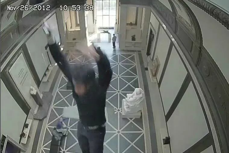 A frame from a museum surveillance video shows Phani Guthula as he begins to fall 38 feet through a glass ceiling to the museum floor. He was seriously injured.