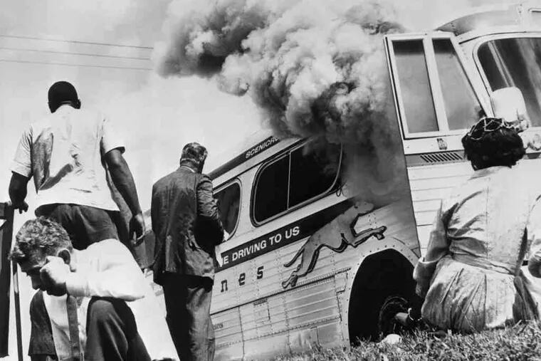 A Greyhound bus carrying Freedom Riders burns in Alabama after a white mob firebombed it on May 14, 1961.