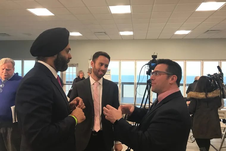 Ed Potosnak, executive director of the New Jersey League of Conservation Voters, speaks with Attorney General Gurbir Grewal and Jeremy Feigenbaum of the Attorney General's office after the announcement of several new environmental justice lawsuits.