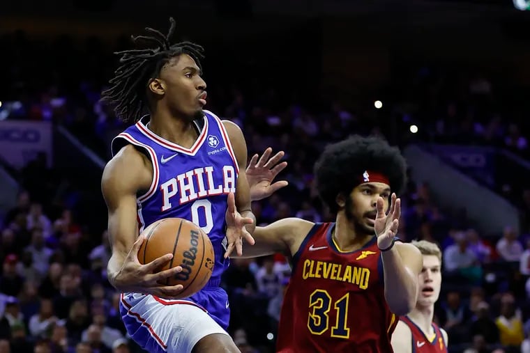 Sixers guard Tyrese Maxey looks to pass the basketball against Cleveland Cavaliers center Jarrett Allen during the first quarter on Friday, March 4, 2022 in Philadelphia.  Maxey was called for a traveling violation on the play.