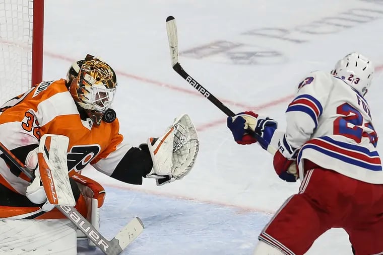 Flyers goalie Felix Sandstrom stops the shot from Rangers Adam Fox with his neck guard during the second period at the Wells Fargo Center in Philadelphia, Wednesday, April 13, 2022.