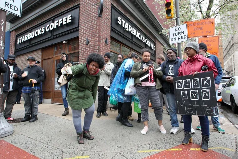 Protestor Aurica Hurst pours out coffee in front of Starbucks at 18th and Spruce Streets on April 16, 2018, as protests continue outside the store where two black men were arrested.