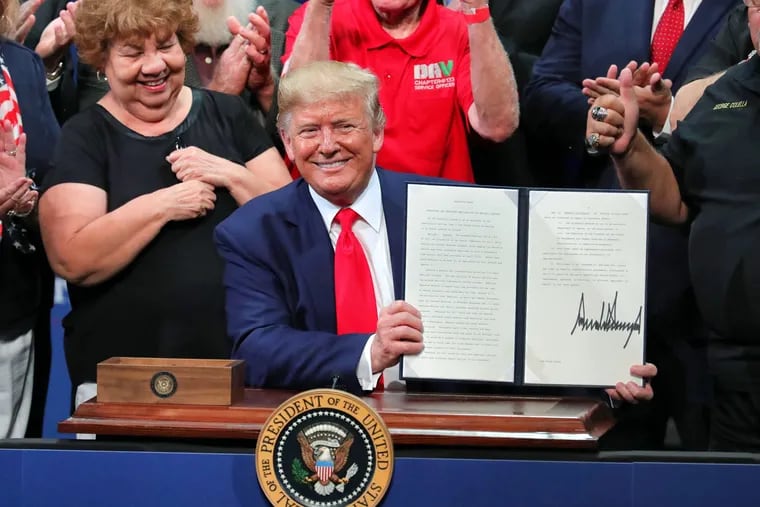 President Donald Trump shows the executive order on Medicare he signed during his appearance at the Sharon L. Morris Performing Arts Center in The Villages, Fla., on Oct. 3.