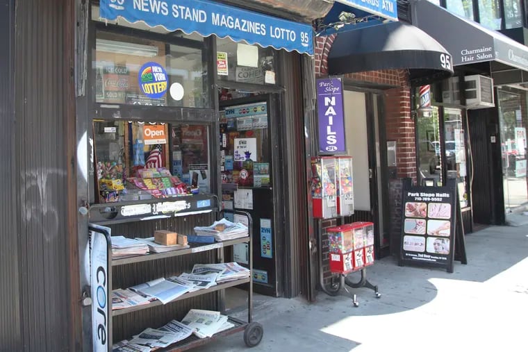 Various local newspapers appear outside a convenience store in the Brooklyn borough of New York on June 30, 2022. The United States continues to see newspapers die at the rate of two per week, according to a report issued Wednesday on the state of local news. The country had 6,377 newspapers at the end of May, down from 8,891 in 2005, the report said.