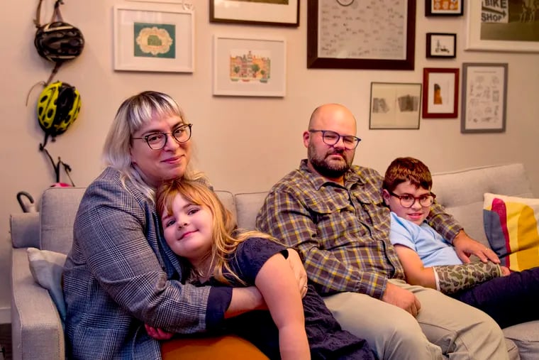 Dena Ferrara Driscoll poses with her family at home in South Philadelphia October 9, 2019. She sits with daughter Juniper, 6; her husband Patrick sits with Milo, 8.