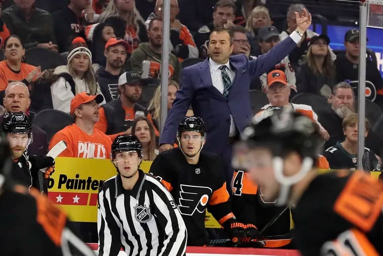 Flyers coach Alain Vigneault gives instructions from his bench during a game.