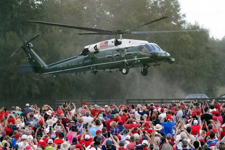 President Donald Trump arrives in the Marine One helicopter at a campaign rally as supporters cheer in The Villages, Fla.