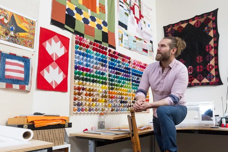 Philadelphia artist Jesse Krimes in his studio in Manayunk. Quilts on the wall include clothing from people who are currently incarcerated. Krimes is the head of the newly launched Center for Art & Advocacy.
