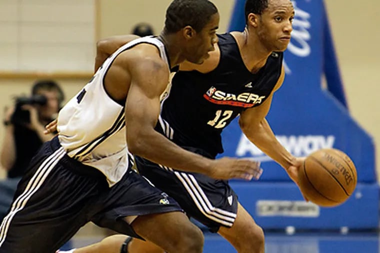 76ers forward Evan Turner drives with the ball as he is guarded by Utah Jazz's Bernard Robinson. (AP Photo/John Raoux)