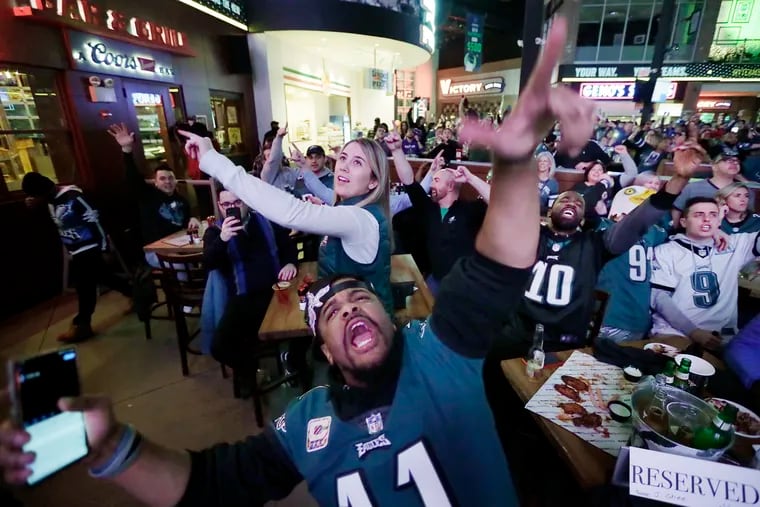 Eagles fans including Anthony Willis of Trenton, N.J. (foreground) celebrate a Birds touchdown while watching the game, at Xfinity Live.