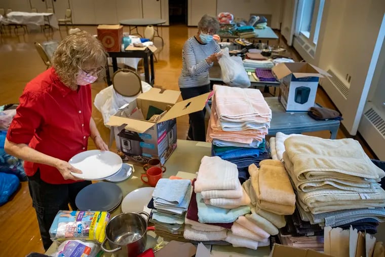 Linda Brock (left) and Adele Margulies organize donations to HIAS Pennsylvania last week at the Main Line Reform Temple in Wynnewood. The donated items are being sorted and organized to help families from Afghanistan.